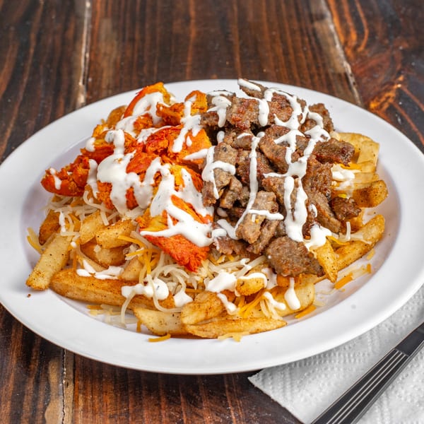 Gyro Guys' fries topped with chicken, gyro meat, shredded cheese, and white sauce.