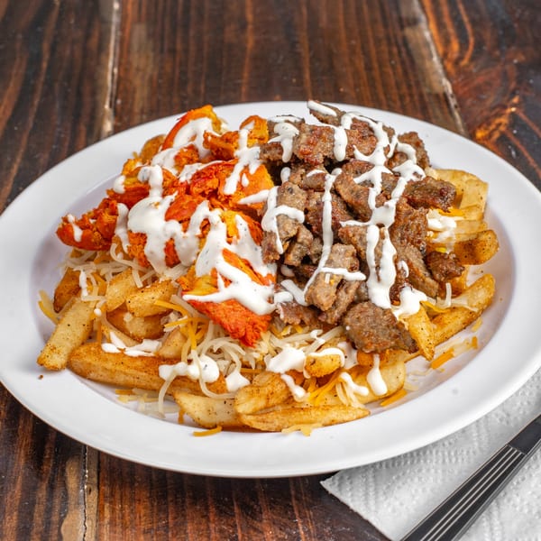 Gyro Guys' fries topped with chicken, gyro meat, shredded cheese, and white sauce.